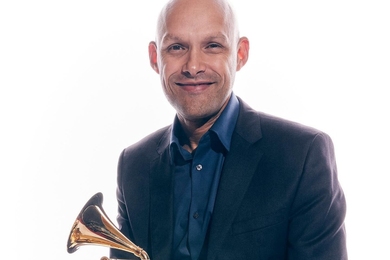 Miguel Zenón poses for with his Grammy Award against a white background