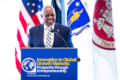 President Masisi speaks at the podium with flags in background. A banner on the podium says, “Innovation in Global Growth Markets.”