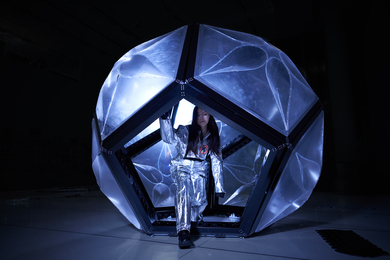 In a darkened room, Katie Chun steps out of the Momo habitat, a geodesic dome-like structure. 