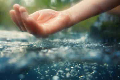 Water flows out of a cupped hand.