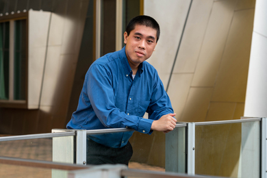 Julian Shun leans on a railing outside of Stata Center.