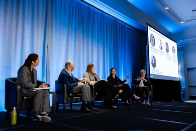 Five people sit on stage during a panel discussion