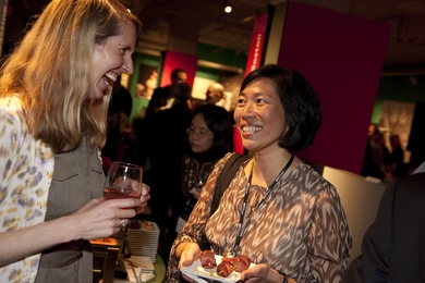 Catherine Kang and an unidentified woman enjoy drinks and appetizers during an indoor reception