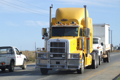 Yellow tractor-trailer truck on a highway