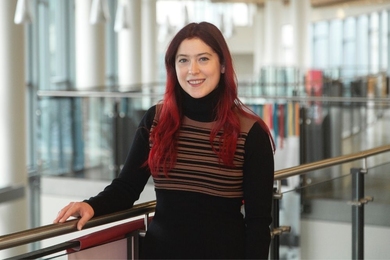 Suzanne Freeman poses on a catwalk over an atrium