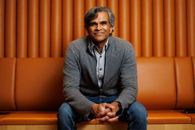 Sendhil Mullainathan poses for a photo on an orange lounge chair 