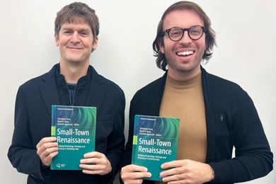 Brent Ryan and Carmelo Ignacolo pose together, each holding up the book “Small Town Renaissance: Bridging Technology, Heritage and Planning in Shrinking Italy.”