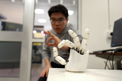 A researcher working with a robotic hand