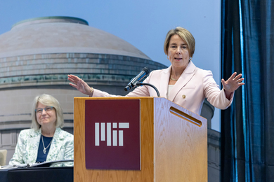Governor Maura Healy speaks at podium as Sally Kornbluth is next to her.