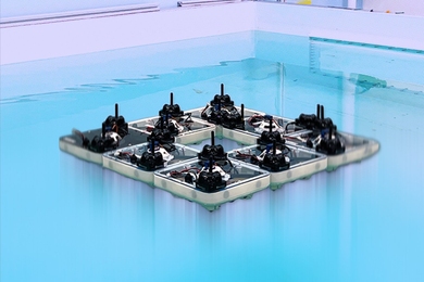 Eight small square robotic boats swarm into a floating diamond-like shape