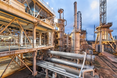 Outdoor photo of a large industrial facility with processing towers, pipes, and equipment