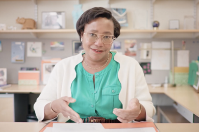 Paula Hammond, seated, speaking to the camera at her desk