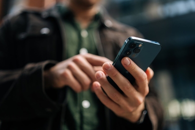 Close-up photo of hands holding and using a smartphone
