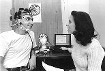 Luca Callini (left), who just received his master's degree in aeronautics and astronautics, looks up at a command from graduate student Suzanne Essig as they work with a piece of headgear that's part of an experiment that will go up on the shuttle with astronaut John Glenn this week. The laptop in the center displays and analyzes physiological signals coming from the headgear.