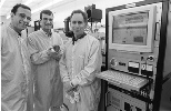 MIT researchers have developed a microchip that releases chemicals on demand. Left to right: Professor Michael Cima, graduate student John Santini and Professor Robert Langer stand in the Microsystems Technology Laboratory where the chip was fabricated. Mr. Santini holds a silicon wafer containing 21 of the dime-sized chips.