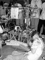 MIT team member Erix Wilhelm tightens the chain on the MIT/CRLS Psychedelic Team robot entry in the FIRST competition.