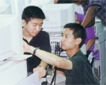 On his trip to China, MIT student Roger Hu (right) gives some computer instruction to a student from a high school attached to Tsunghua University.