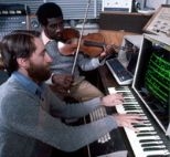 Professors Barry Vercoe and Marcus Thompson working in front of a graphical score editor, circa 1976.