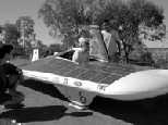 Student SEVT members Brian Graham (crouching), Nathan Ickes (standing, left) and Iahn Cajigas (standing, right) help driver Jacinda Clemenzi into the Manta GTX before starting a leg of the Australian World Solar Challenge.