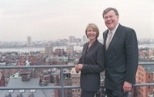 Lore Harp McGovern and Patrick McGovern Jr. at IDG's Boston headquarters, with the Cambridge and MIT skyline in the background.