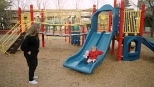 Loni Butera watches her daughter Lara enjoying the slide in the new playground at Westgate.