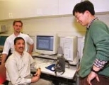 James Biggs, postdoctoral associate in the Research Lab of Electronics (left), Professor Mandayam Srinivasan, director of MIT's Touch Lab, and mechanical engineering graduate student Jung Kim observe the movement of a robotic arm driven by signals from a monkey at Duke University.