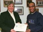 Campus Police Chief Anne P. Glavin presents senior Ricardo Dawkins with a citation recognizing his bravery in assisting state and campus police in pulling a woman out of a burning car on Memorial Drive.