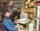 Research scientist Chris E. Forest (seated), Professor Peter H. Stone and research scientist Andrei P. Sokolov (right) gather around a monitor displaying their climate model, which reduces the uncertainty of global climate change predictions. On the screen is a temperature record for the global mean surface temperature from 1900 to 1998.