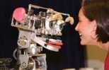 Dr. Cynthia Breazeal plays with Kismet, the robot that mimics and responds to human emotions.