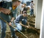 HST students and others get elbow-deep in yard work on the first Community Service Day at McInnis House in Jamaica Plain.