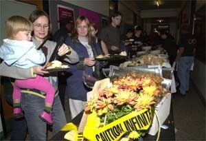Architecture graduate student Dorothy Shamonsky holds Iris, 2, who looks interested in some taste-testing as they go through the food line at the Infinite Buffet. Iris' twin sister Lily and father Andy Bennet (not pictured) were also in attendance.