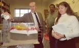 Peter Lavelle, a computer science teacher at the Pierce School in Brookline (left); Mohamud Yousuf, who teaches at Community Solutions Inc. in Roxbury for the Department of Youth Services (center); and Laura LaBrie, a kindergarten teacher in Holliston Public Schools, show how water moves through the model they constructed of a cross-section of soils beneath a small farming town.