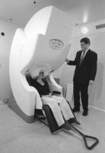 Valerie Carr, chief technologist for MEG, demonstrates the new imaging system as Seppo Ahlfors, technical director of MEG, looks on. Using scientific approaches pioneered by Martinos Center researchers, the combined MEG and MRI data from new facilities at the center will produce "movies" of the brain at work.