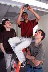 Robert Morris, Hari Balakrishnan and Frans Kaashoek,  faculty in the Laboratory for Computer Science, attach a low-cost beacon for Project  Oxygen's Cricket Indoor Location System.