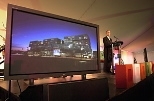 Simmons Hall is aglow on screen to President Charles Vest's right at the dedication of the new dorm last Friday.