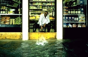 A Venetian grocer wears waders while minding the store.