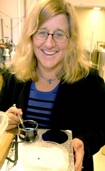 Professor Karen Gleason shows how water seeped in to conventional fabric, and beaded up like a marble on fabric treated with her new waterproofing technique.