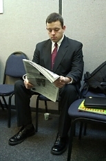 David Gutierrez, a senior in electrical engineering and computer science, reads a newspaper while waiting his turn for a job interview.