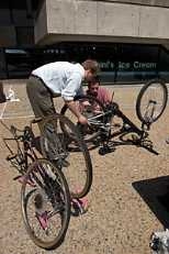 Graduate students Wojciech Giziewicz (standing) and Christopher Guerra do bicycle maintenance during Earth Day activities on Kresge Oval.