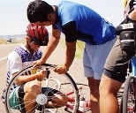 Taku Iida (standing) helps Kyle Rattray repair his second flat tire, just outside Billings, Mont.