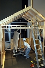 Dale Cotton, a junior in mechanical engineering, demonstrates the drywall/sheetrock lift and installation system designed and built by his team in 2.009 (Product Engineering Processes).