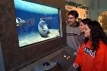 The creators of iQuarium, a virtual underwater environment that shows how fish swim, try out the interactive exhibit in the Hart Nautical Gallery. Left to right: Aaron Sokoloski, a junior in mechanical engineering; Audrey Roy, a senior in electrical engineering and computer science; and Katie Wasserman, a senior in ocean engineering.