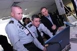 "TacShot" team leader Andrew Heafitz (right) looks on as Army Command Sgt. Maj. Michael Kelso (left) and Col. Ernest Forrest, judges at the Soldier Design Competition, review project submissions.