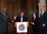 Cambridge City Council member and former mayor Kenneth Reeves (left) and Mayor Michael Sullivan (at podium) share a laugh with Rebecca Vest and President Charles M. Vest as they present the Vests with a key to the city at the MIT Community Service Awards ceremony. The Vests were recognized for their commitment to positive town-gown relations during their 14 years in the President's House.