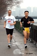 Triathletes Ken Ross, a computational biologist at the Broad Institute, left, and Harn Wei Kua, an MIT graduate student in architecture and mechanical engineering, train by the Charles River. Ken will run in the Boston Marathon on Monday, April 19.