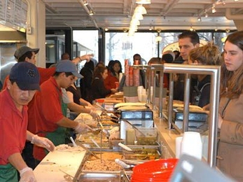 The fingers of the cooks at Anna's Taqueria flew as they put together yummy burritos and quesadillas for the hoardes that descended when the Mexican food eatery opened on campus Feb. 9. Behind the counter are Enrique Olivera, far left foreground, Nestor Olivera, also at counter, and Melvin Garcia (pointing).