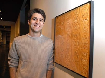 Winner of the 'Weird Fields' competition George Zaidan stands beside his winning print, which is hanging in the MIT Museum.