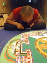 Lama Dhondup Tsering, a Buddhist monk, works painstakingly Monday to create a sand mandala at Simmons Hall. It will be on view through Saturday.