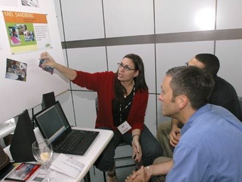Yael Sandberg of Brazil, a participant in the IDEAS Institute for Innovative Design Experiences After School, shared information about her project at a June 28 event at the MIT Media Lab. Amon Millner (hidden), a grad student at the MIT Media Lab, and Tony Streit, director of the YouthLearn Initiative at the Educational Development Center in Newton, listen.