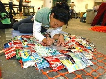 MiHae Chang, a junior in architecture, puts the finishing touches on the can doorway of her team's portable homeless shelter. Working in teams of four or five, students had five days to design and build the individual shelters for Professor Jan Wampler's architecture class.